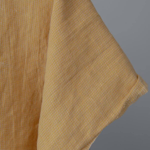 Washed linen cotton fabric in yellow-sand small pattern edge view