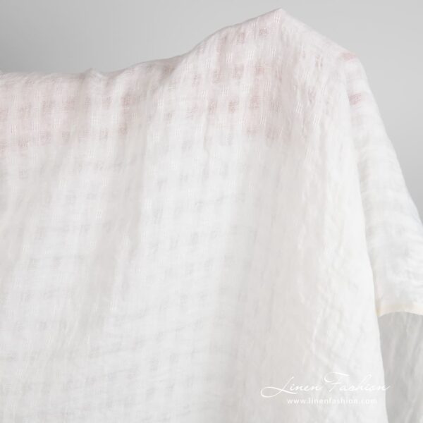 Off-white linen fabric in transparent checks, specially washed to increase softness
